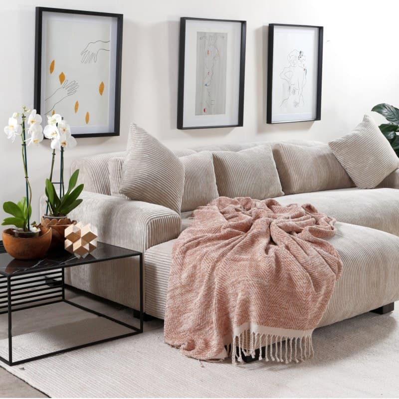 A Candy Chaise End Sofa in a beautifully designed living room, with coffee table, rug and art.