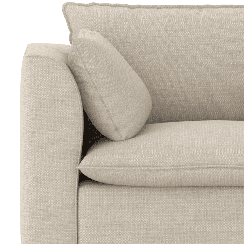 Close up of the curved arm of a beige Daisy sofa from Scooch, highlighting the shape of the arm and the scatter cushion