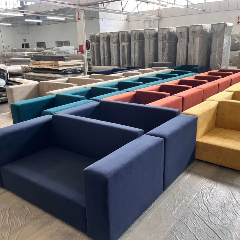 3 rows of blue, red and yellow Scooch sofas and armchairs fill the warehouse before delivery to the G20 summit